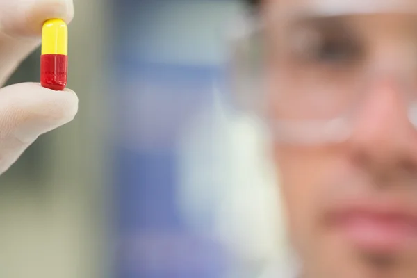 Extreme close-up of a male scientist analyzing pill — Stock Photo, Image