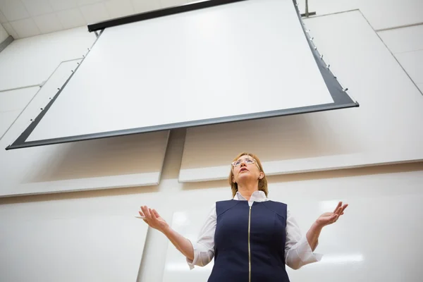 Female teacher with projection screen in the lecture hall — Stock Photo, Image