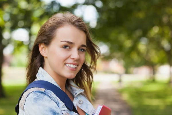 Ganska glad student håller mapp och bärbara — Stockfoto