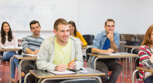 Mladí studenti, usmíval se v učebně — Stock fotografie