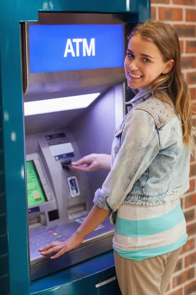 Estudiante bastante sonriente retirando dinero — Foto de Stock