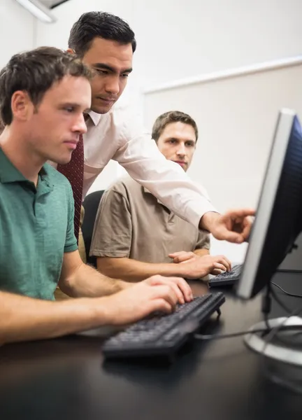 Enseignant et étudiants matures dans la salle informatique — Photo