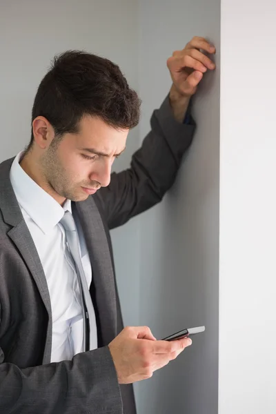 Handsome serious businessman looking at smartphone — Stock Photo, Image