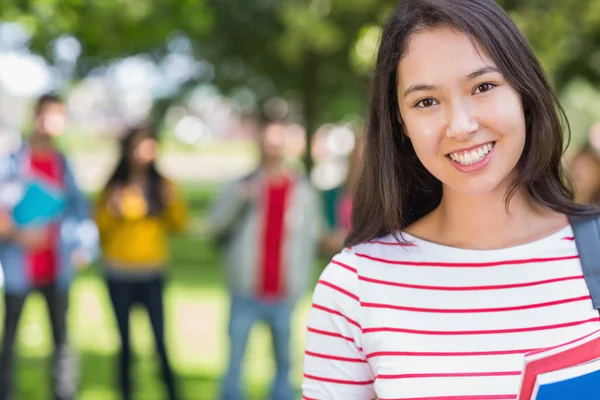 Gros plan de la collégienne avec des étudiants flous dans le parc — Photo