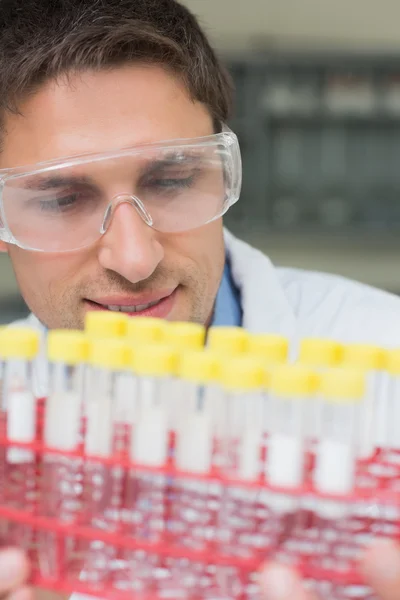 Pesquisador masculino olhando para tubos de ensaio no laboratório — Fotografia de Stock