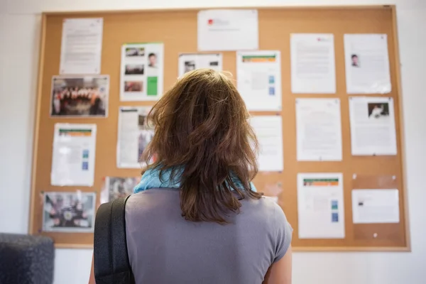 Student studying notice board — Stock Photo, Image