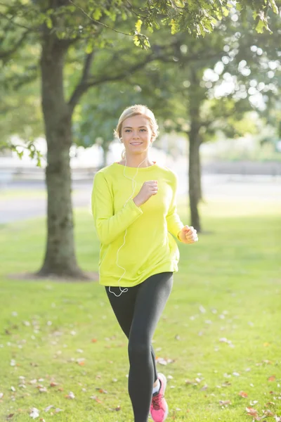 Aktive glückliche Blondine joggt in Richtung Kamera — Stockfoto