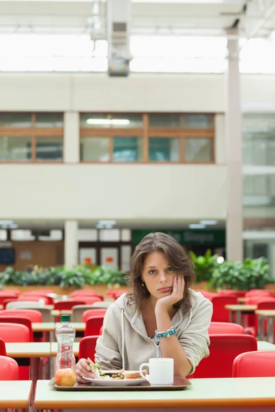 Gloomy student in the cafeteria with food tray — Stock Photo, Image