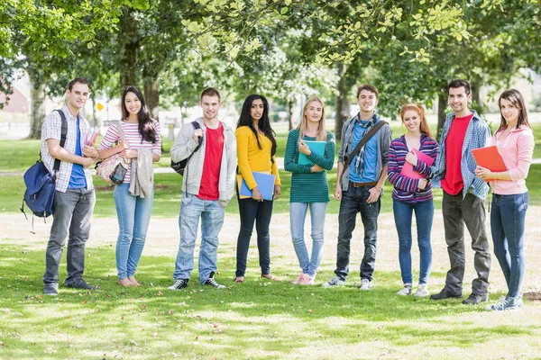 Студенты колледжа с сумками и книгами стоят в парке — стоковое фото