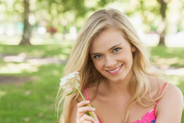 Retrato de linda jovem mostrando uma flor branca — Fotografia de Stock