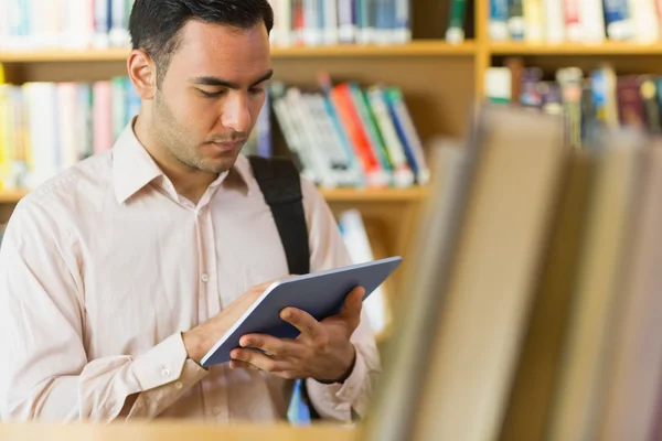 Koncentrerad mogen student använda TabletPC i biblioteket — Stockfoto