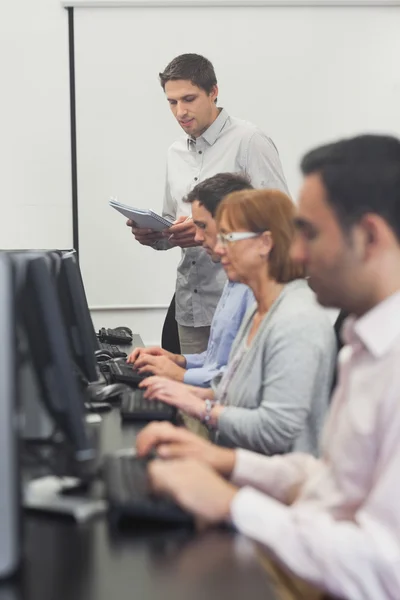 Teacher standing in front of computer class — Stock Photo, Image