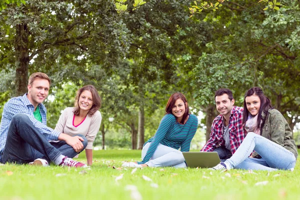 Jóvenes estudiantes universitarios usando laptop en el parque —  Fotos de Stock