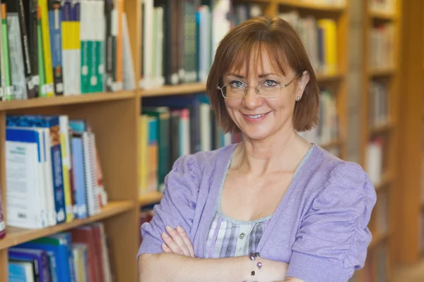 Mogen intellektuell kvinna poserar i biblioteket — Stockfoto