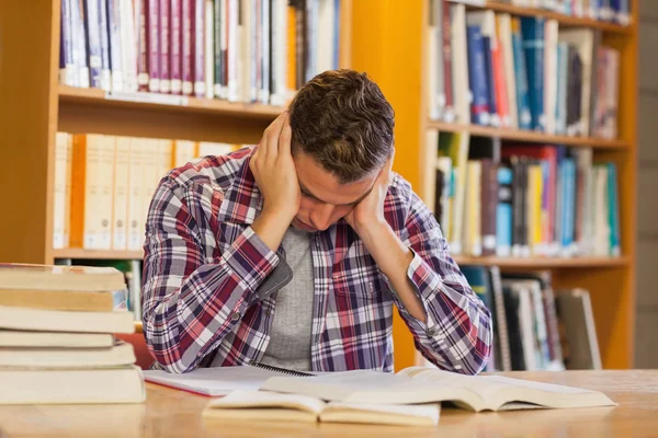 Bonito estudante frustrado estudando seus livros — Fotografia de Stock
