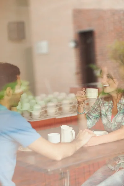 A couple holding hands and drinking coffee — Stock Photo, Image