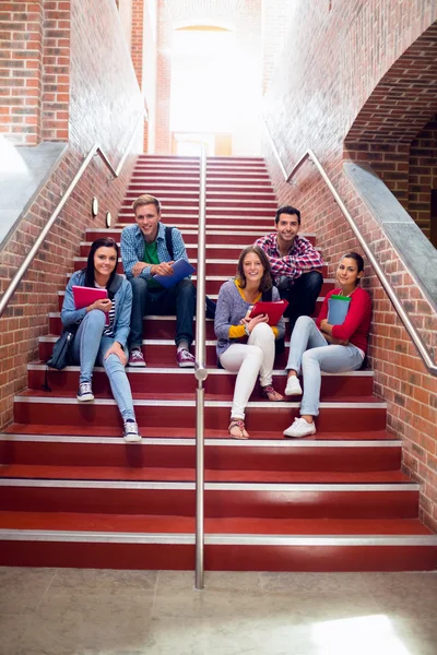 College students sitting on stairs in the college — Stock Photo, Image