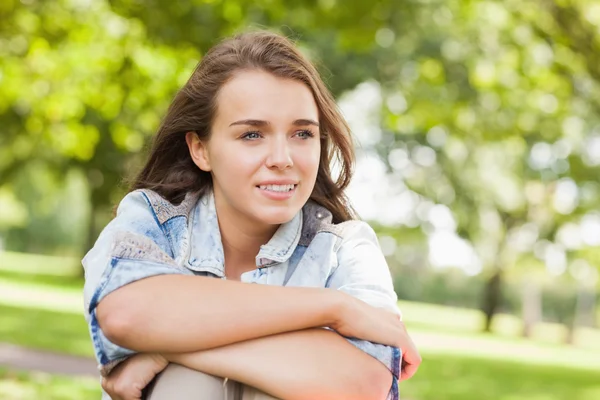 Estudiante bastante sonriente sentado en la hierba — Foto de Stock