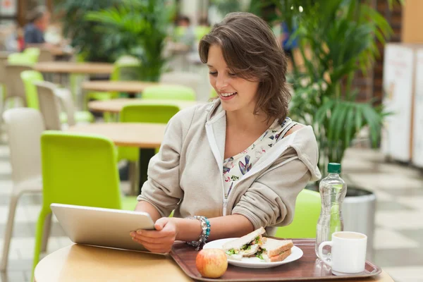 Kvinna med hjälp av TabletPC i cafeterian — Stockfoto