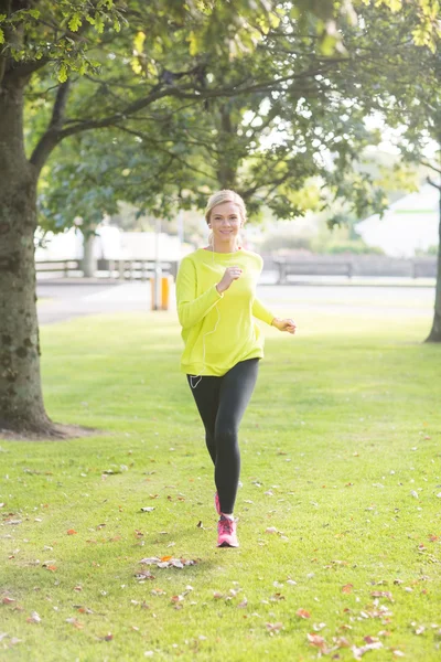 Aktiva leende blondin jogging mot kameran — Stockfoto