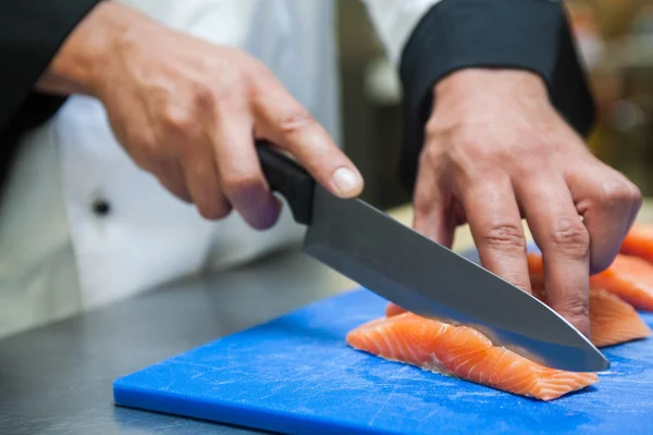 Close up of chef slicing salmon with sharp knife — Stock Photo, Image