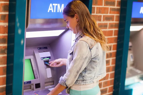 Bonita estudiante morena retirando dinero — Foto de Stock