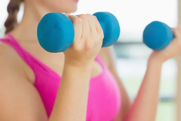 Střední část ženy cvičení s činkami v fitness stud — Stock fotografie