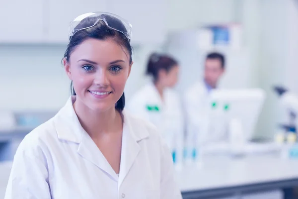 Ricercatrice con colleghi di background in laboratorio — Foto Stock