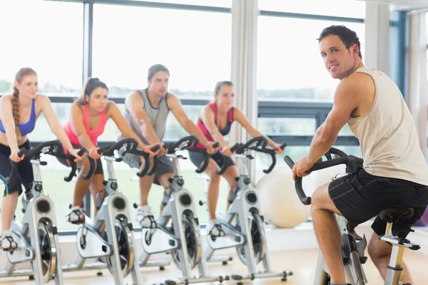 Hombre enseñando spinning clase a cuatro personas —  Fotos de Stock