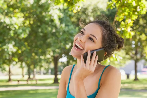 Mujer joven feliz telefoneando con su teléfono inteligente — Foto de Stock