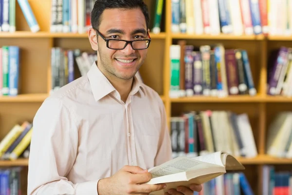 Sorrindo livro de leitura de estudante maduro na biblioteca — Fotografia de Stock