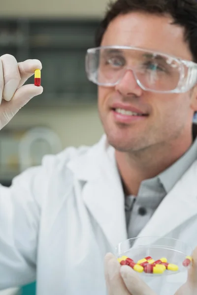 Cientista do sexo masculino analisando pílulas em laboratório — Fotografia de Stock