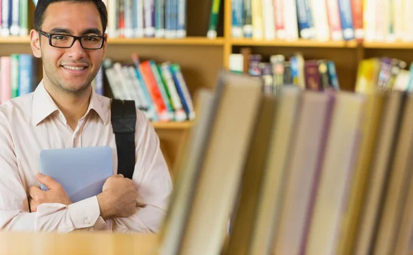 Estudante maduro sorridente com tablet PC na biblioteca — Fotografia de Stock