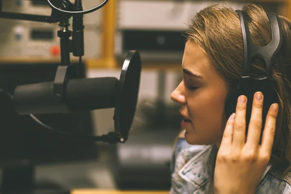 Jolie chanteuse concentrée enregistrant une chanson — Photo