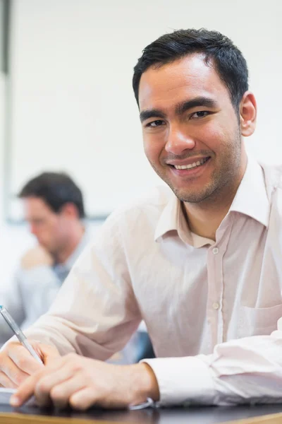 Mature students taking notes in classroom — Stock Photo, Image