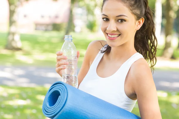 Conteúdo ativo morena segurando tapete de exercício — Fotografia de Stock