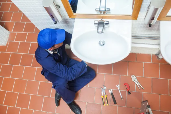 Loodgieter met GLB herstellen wastafel — Stockfoto