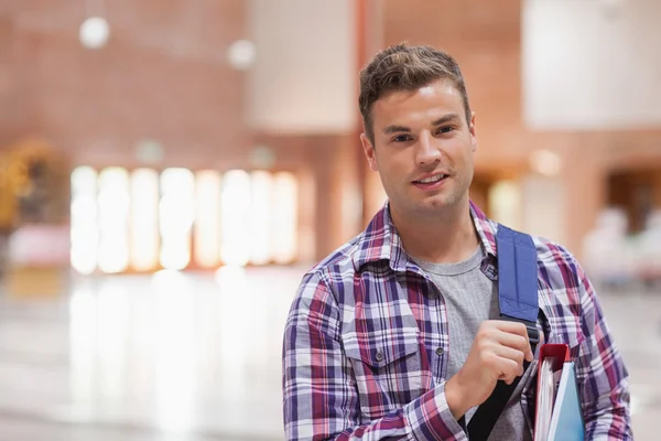 Lachende knappe student permanent in school — Stockfoto