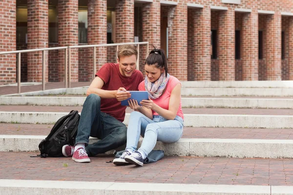 Estudiantes felices sentados en escaleras usando tableta —  Fotos de Stock