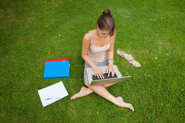 Student med laptop med böcker på park — Stockfoto