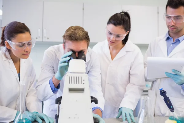 Cientistas com microscópio no laboratório — Fotografia de Stock