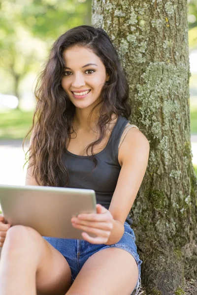 Dorywczo atrakcyjny brunetka siedzący za pomocą tabletu — Zdjęcie stockowe
