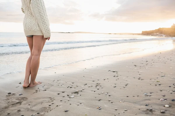 Sección baja de una mujer en suéter de pie en la playa —  Fotos de Stock