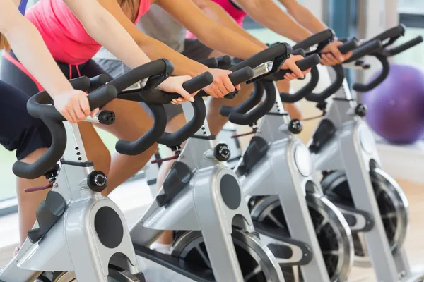 Medio sector de la gente haciendo ejercicio en la clase de spinning — Foto de Stock