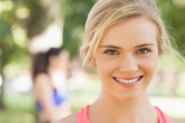 Wunderschöne junge blonde Frau posiert in einem Park — Stockfoto