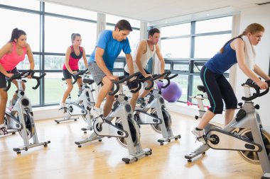 Determined people working out at spinning class clipart