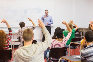 Students raising hands in the classroom clipart