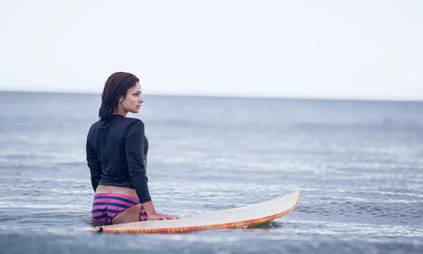 Vue arrière d'une femme avec planche de surf dans l'eau — Photo