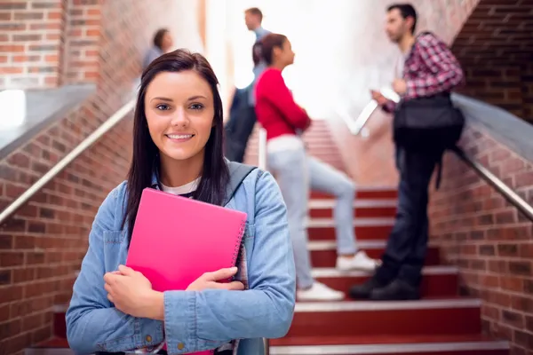 Female holding books with students on stairs in college — Stock Photo, Image