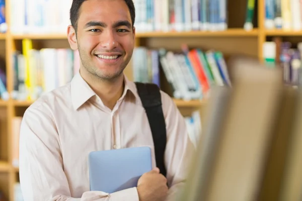 Estudante maduro sorridente com tablet PC na biblioteca — Fotografia de Stock